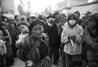 Interplast, 102-032-05
Una donna con un bambino in spalla, circondati da altre persone del luogo, 2004
Shigatse (Cina, Tibet)